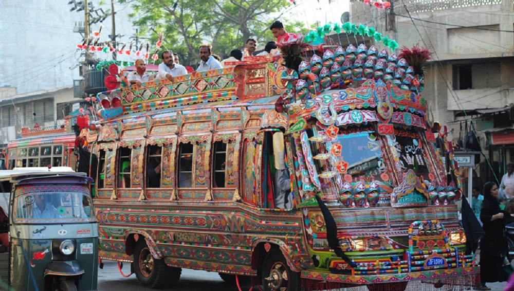 Decorated Karachi mini bus on a city road at golden hour